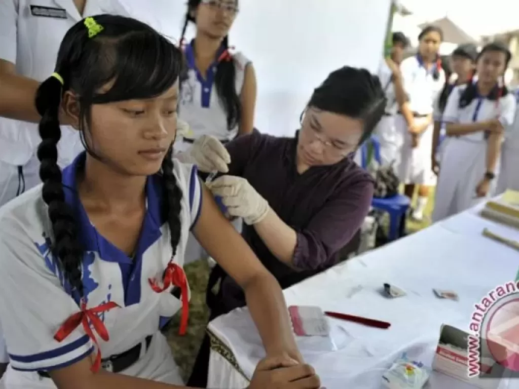 Seorang siswi SMA (kiri) mendapatkan vaksin kanker serviks secara gratis pada vaksinasi massal tahap I di Pemkab Badung, Bali, Senin (12/11/2016). (ANTARA/Nyoman Budhiana)