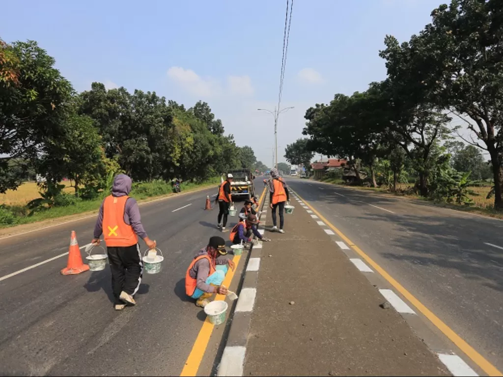 Sejumlah pekerja menyelesaikan pengecatan marka jalan di jalur pantura Widasari, Indramayu, Jawa Barat. (ANTARA FOTO/Dedhez Anggara)