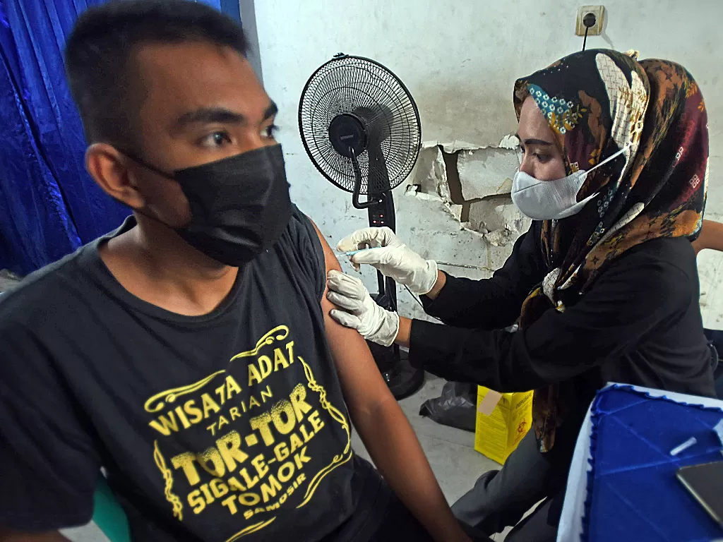 Petugas menyuntikkan vaksin COVID-19 kepada calon penumpang angkutan umum yang akan mudik di Terminal Pakupatan Kota Serang, Banten, Jumat (22/4/2022). (ANTARA FOTO/Asep Fathulrahman)