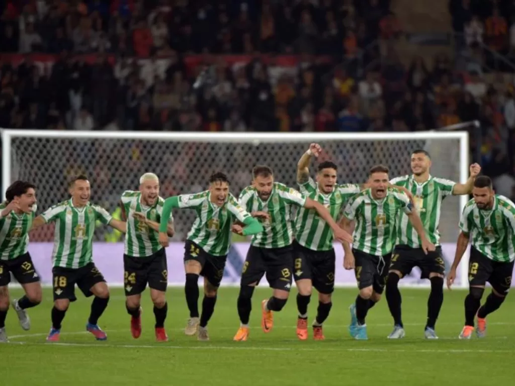 Para pemain Real Betis merayakan sukses mereka merebut trofi Copa del Rey setelah dalam final mengalahkan Valencia CF di La Cartuja Stadium di Seville dalam adu penalti pada 23 April 2022. (AFP/CRISTINA QUICLER)