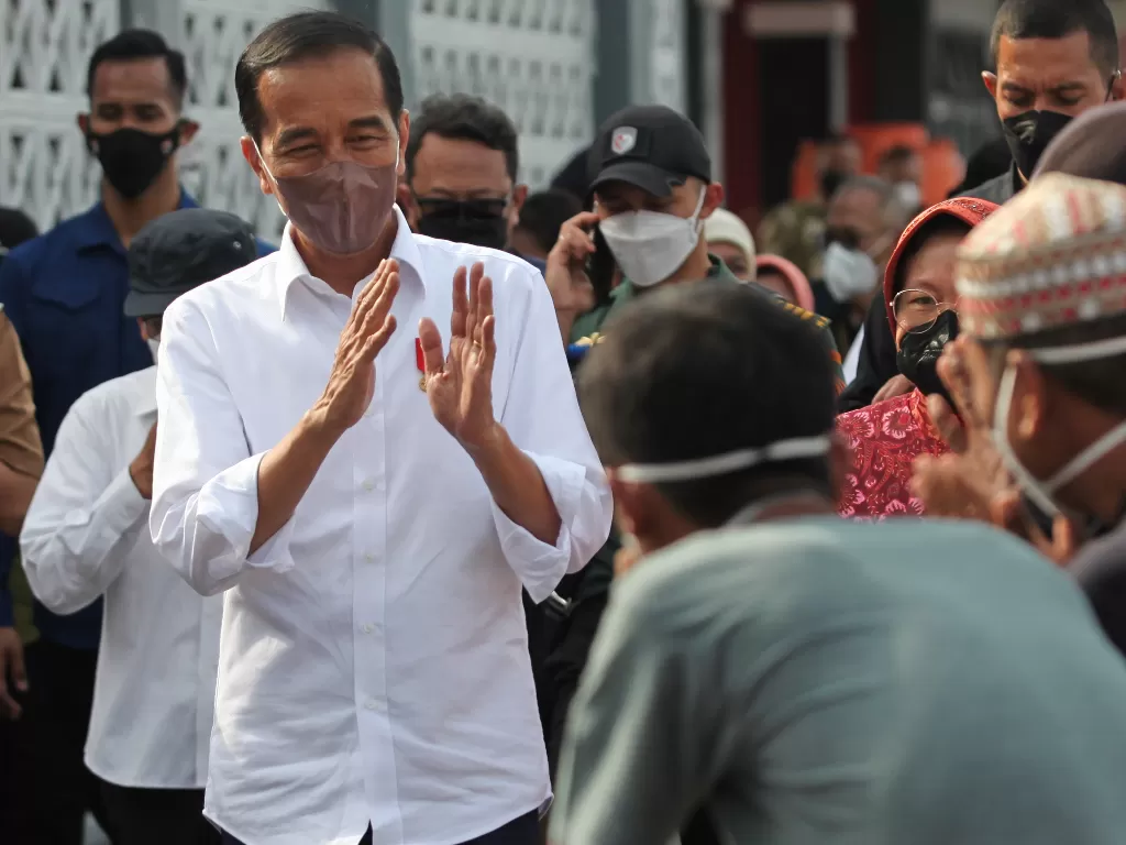 Presiden Joko Widodo (kiri) memberi salam kepada sejumlah nelayan. (ANTARA/Didik Suhartono)