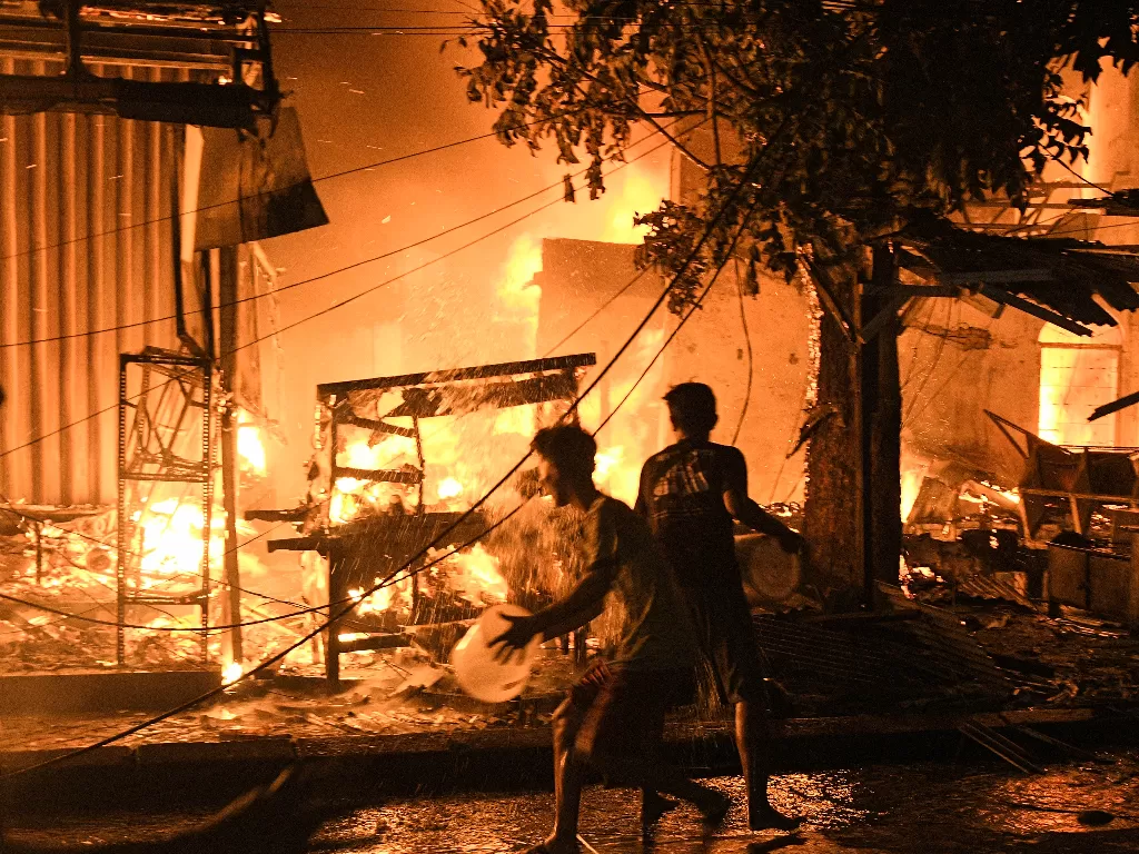 Sejumlah warga memadamkan api yang membakar kios dan rumah di pasar Gembrong, Jatinegara, Jakarta Timur, Minggu (24/4/2022). (ANTARA/Fakhri Hermansyah)