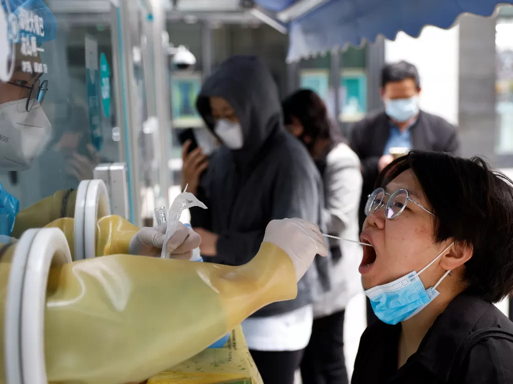 Seorang warga di Beijing melakukan tes PCR. (REUTERS/Carlos Garcia Rawlins)