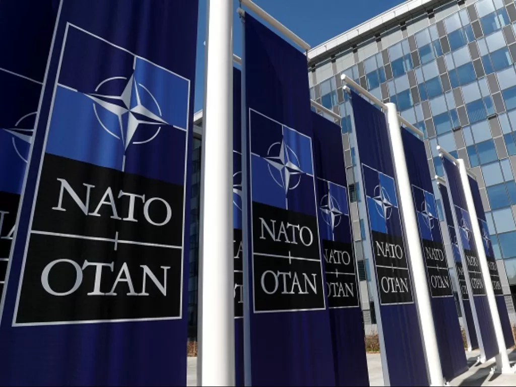 Baner yang menunjukkan logo NATO. (REUTERS/Yves Herman)