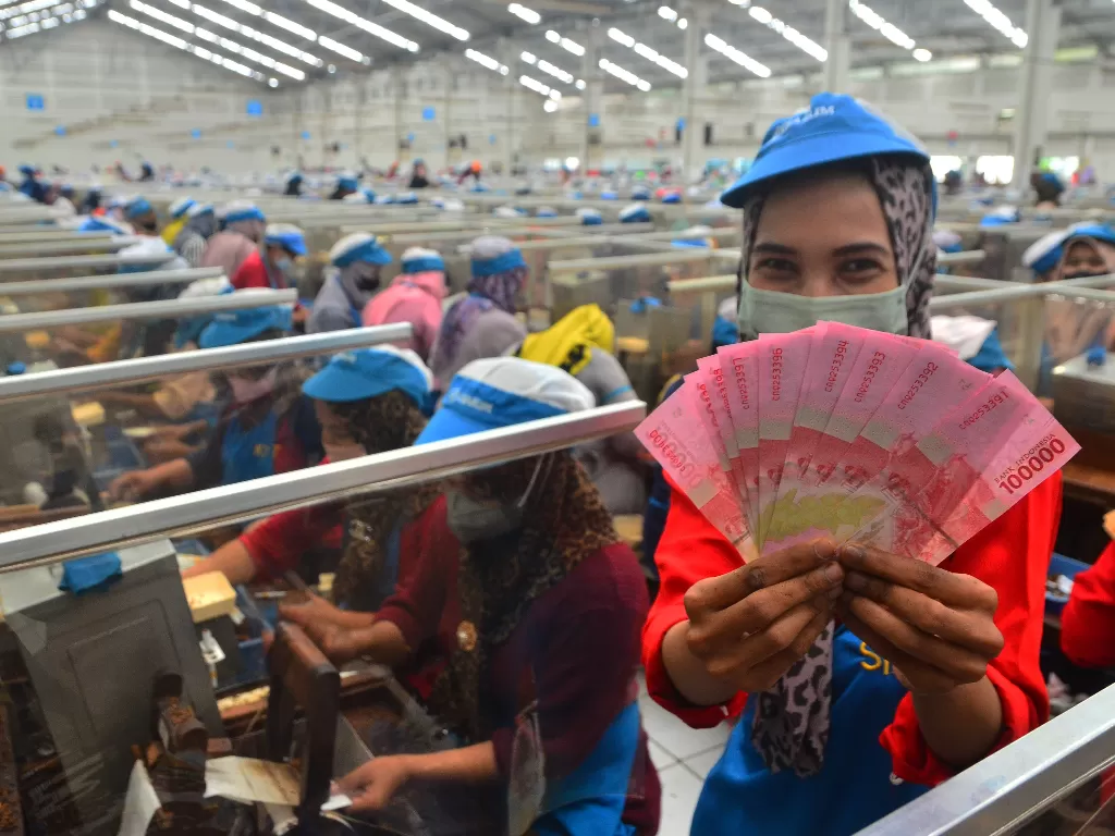 Pekerja menunjukkan uang Tunjangan Hari Raya (THR) yang diterimanya di pabrik rokok PT Djarum, Kudus, Jawa Tengah, Selasa (19/4/2022). (ANTARA/Yusuf Nugroho)