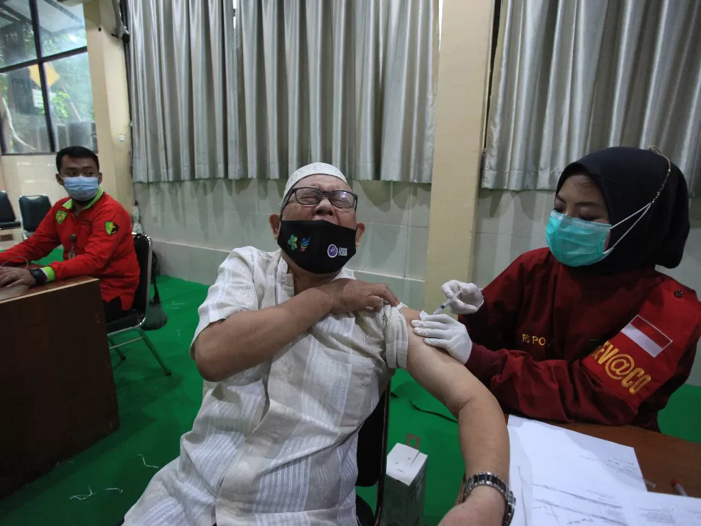 Tenaga kesehatan menyuntikan vaksin penguat atau booster kepada warga, di Gedung PBNU, Jalan Kramat Raya, Jakarta, Kamis (21/4/2022). (ANTARA/Reno Esnir)
