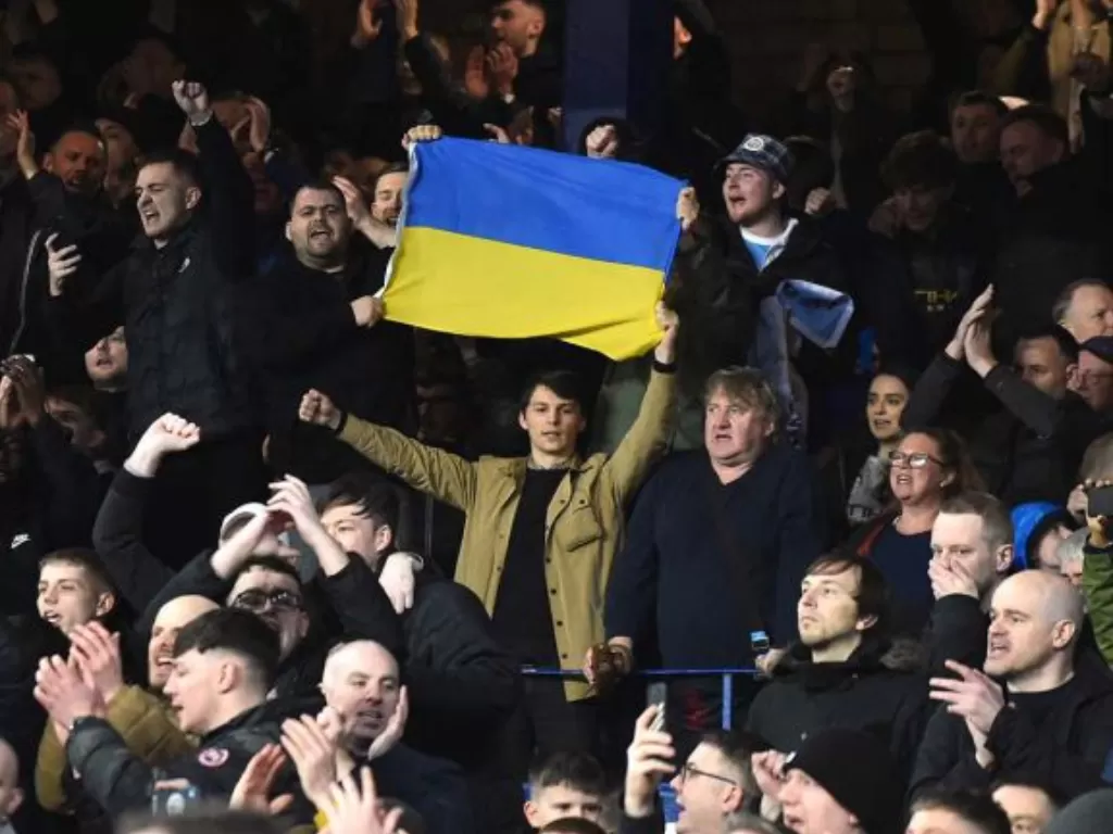 Penonton mengibarkan bendera Ukraina sebelum pertandingan laga Liga Inggris antara Manchester City melawan Everton di Goodison Park, Liverpool, Inggris (26/2/2022). (ANTARA FOTO/REUTERS/Peter Powell/aww)
