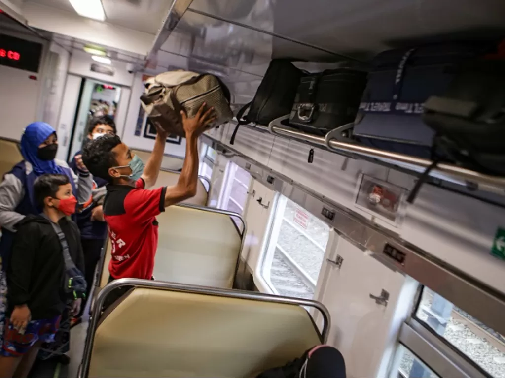 Petugas membantu penumpang untuk menaruh barang di dalam kereta di Stasiun Pasar Senen, Jakarta. (ANTARA FOTO/Fauzan)