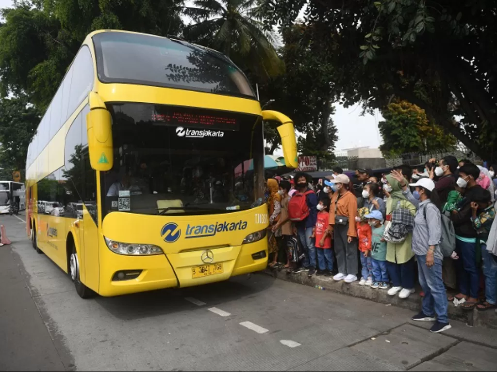 Warga antre untuk masuk ke dalam bus wisata gratis Transjakarta di Jakarta. (ANTARA FOTO/Akbar Nugroho Gumay)