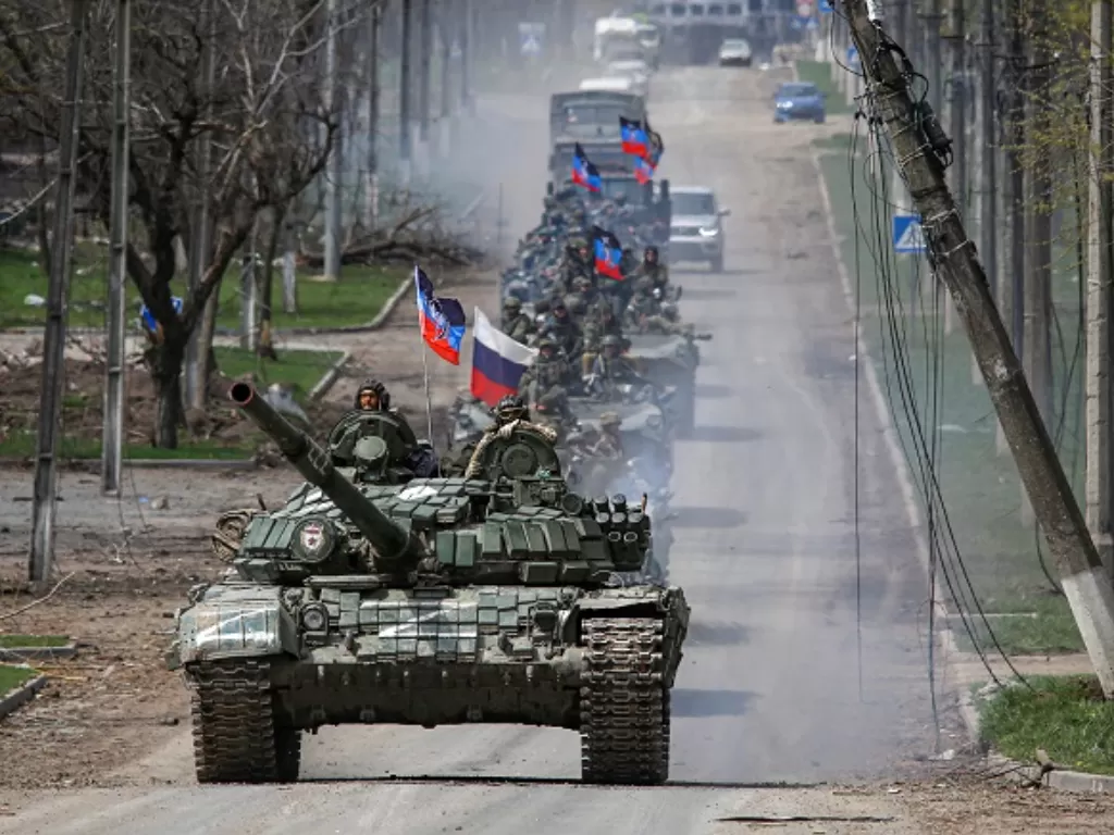 Pasukan Rusia melewati pusat kota Mariupol, Ukraina. (REUTERS/Chingis Kondarov)