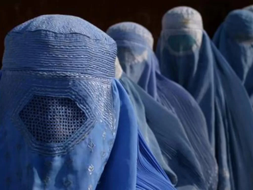 Wanita Afghanistan mengenakan burqa berbaris di pusat distribusi makanan yang dikelola oleh CARE internasional di Kabul, Afghanistan. (REUTERS/Ahmad Masood)
