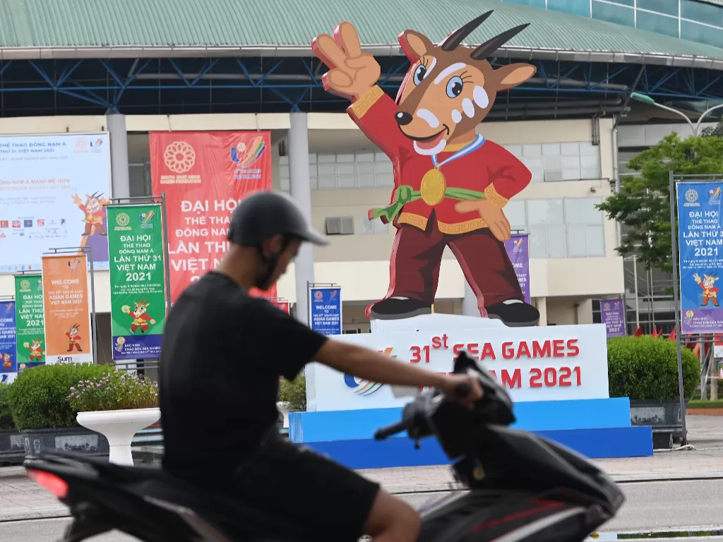 Pengendara sepeda motor melintasi gambar maskot SEA Games 2021 Vietnam, Hanoi Saola, di Kota Bac Ninh, Vietnam, Minggu (8/5/2022). (ANTARA FOTO/Aditya Pradana Putra)