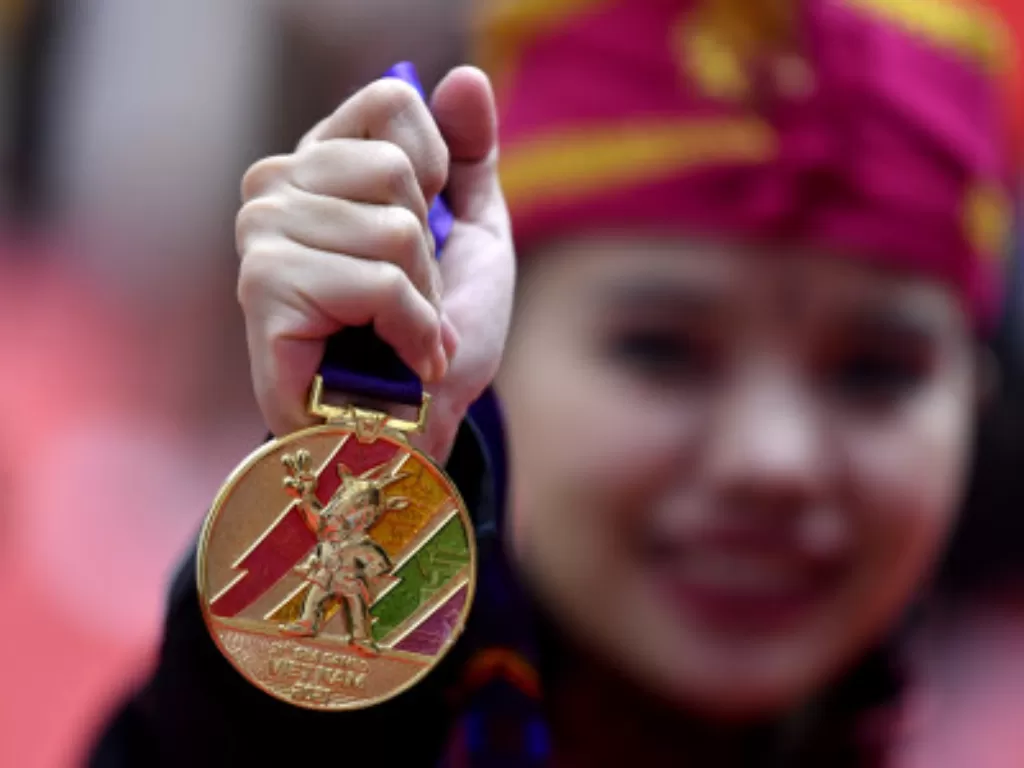 Pesilat Indonesia Riska Hermawan menunjukkan medali emas yang diraih pada final Seni Ganda Putri Pencak Silat SEA Games 2021, Rabu (11/5/2022). (ANTARA FOTO/Zabur Karuru)