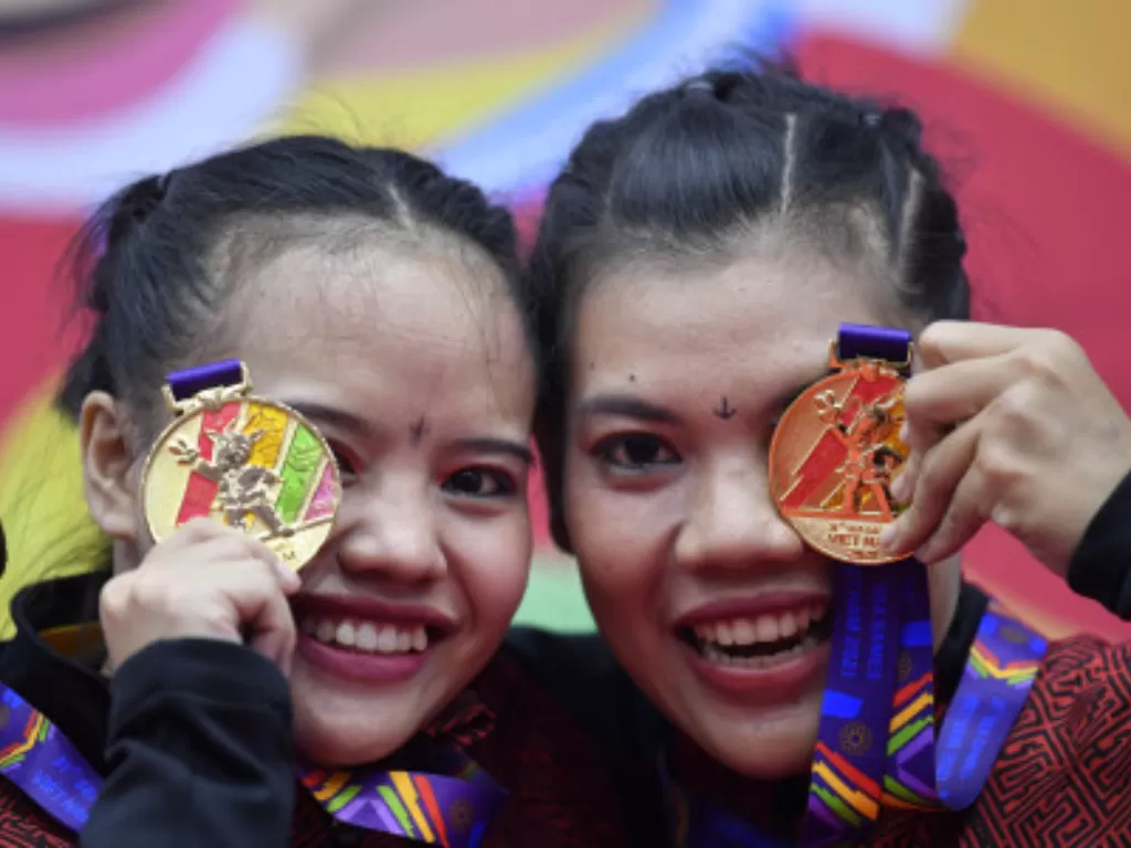 Ilustrasi - Pesilat Indonesia Riska Hermawan (kiri) dan Ririn Rinasih (kanan) berpose dengan medali emasnya yang diraih pada final Seni Ganda Putri Pencak Silat SEA Games 2021 Vietnam. (ANTARA FOTO/Zabur Karuru)