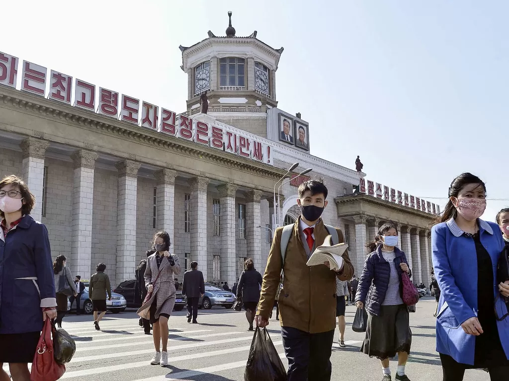 Ilustrasi orang berjalan menggunakan masker di tengah COVID di Korea Utara Meningkat. (Mandatory credit Kyodo/via REUTERS)