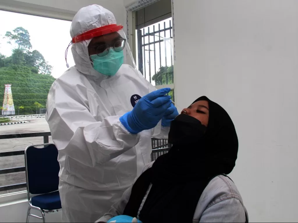 Petugas Karantina Kesehatan Pelabuhan melakukan tes antigen kepada Warga Negara Indonesia (WNI) yang pulang dari Sarawak, Malaysia. (ANTARA FOTO/Jessica Helena Wuysang)