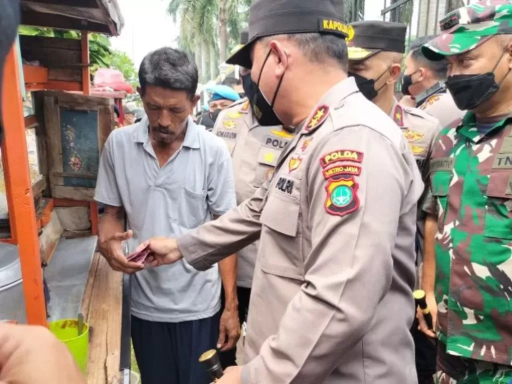 Kapolda Metro Jaya, Irjen Pol Fadil Imran, memberikan sejumlah uang kepada Mulyanto selalu pedagang bakso yang berdagang di depan gedung Parlemen, Sabtu, (14/5/2022) (ANTARA / Walda)