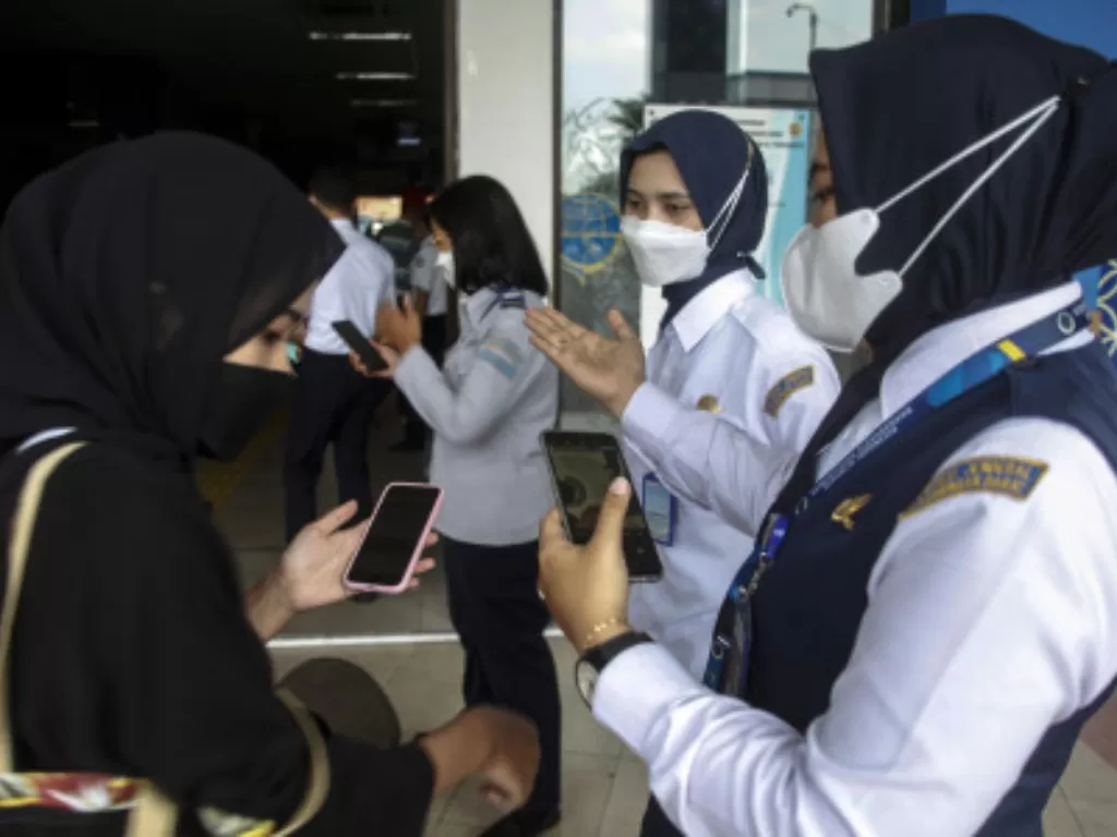 Petugas memeriksa sertifikat vaksin COVID-19 dan membagikan masker bagi penumpang yang tiba di Terminal Tirtonadi Solo, Jawa Tengah (Ilustrasi/ ANTARAFOTO/Maulana Surya)