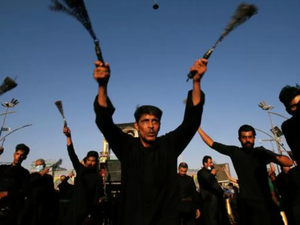  Warga Muslim Syiah mencambuk tubuh sendiri dengan rantai besi untuk memperingati Asyura, di Kerbala, Irak, 29 Agustus 2020. Bagi Muslim Syiah, Asyura merupakan hari paling suci. (REUTERS/Abdullah Dhiaa Al-Deen)