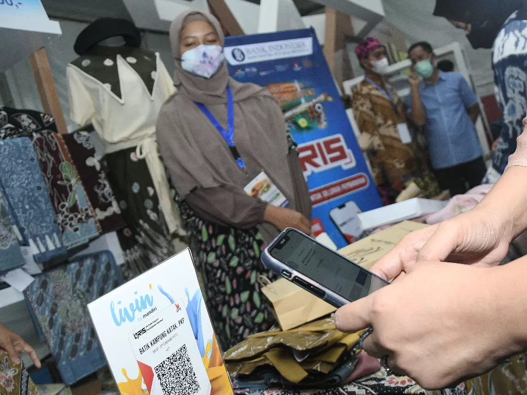 Pengunjung memindai kode QR saat bertransaksi pada acara Gerakan Nasional Bangga Buatan Indonesia. (ANTARA/Fakhri Hermansyah)