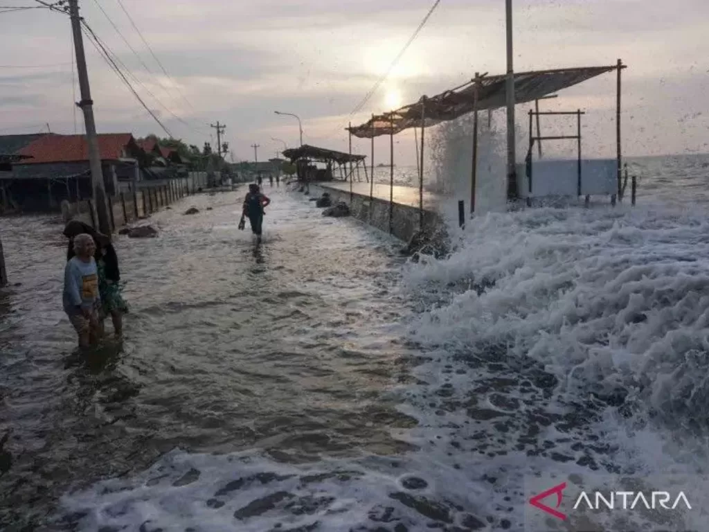 Sejumlah warga berjalan menghindari gelombang air laut di pesisir pantai Utara, Pekalongan, Jawa Tengah, Senin (23/5/2022). (ANTARA FOTO/Harviyan Perdana Putra)