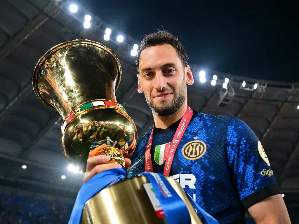 Hakan Calhanoglu memegang trofi Coppa Italia musim 2021/2022. (REUTERS/Alberto Lingria)