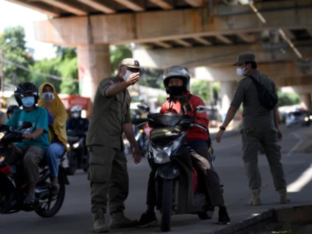 Ilustrasi - Anggota Satpol PP menegur pemotor yang tak pakai masker saat razia protokol kesehatan PPKM level 2 di Pondok Labu, Jakarta, Selasa (5/4/2022). (ANTARA FOTO/Sigid Kurniawan)