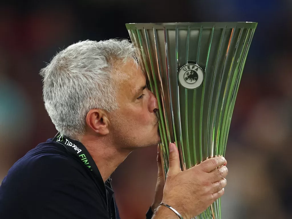 Jose Mourinho mencium trofi usai membawa AS Roma juara UEFA Conference League. (REUTERS/Marko Djurica)