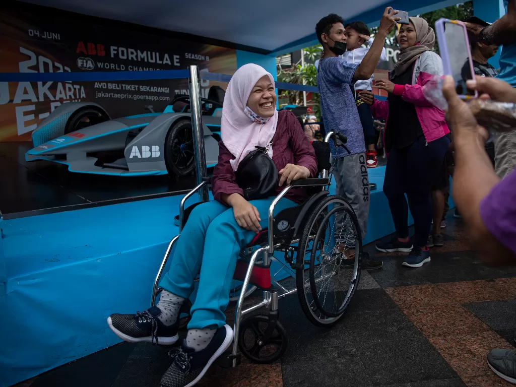 Sejumlah warga menyaksikan replika mobil balap listrik Formula E yang dipamerkan saat hari bebas kendaraan bermotor di Bundaran HI, Jakarta, Minggu (29/5/2022). (ANTARA/Sigid Kurniawan)