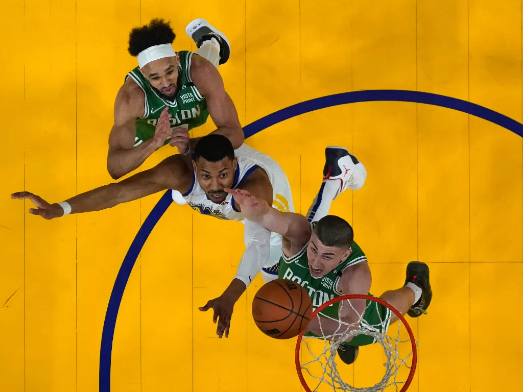 Pemain State Warriors Otto Porter Jr (tengah) berusaha merebut bola rebound dari dua pemain Boston Celtics Payton Pritchard (bawah) dan  Derrick White (atas). (USA TODAY Sports via REUTERS/Kyle Terada)