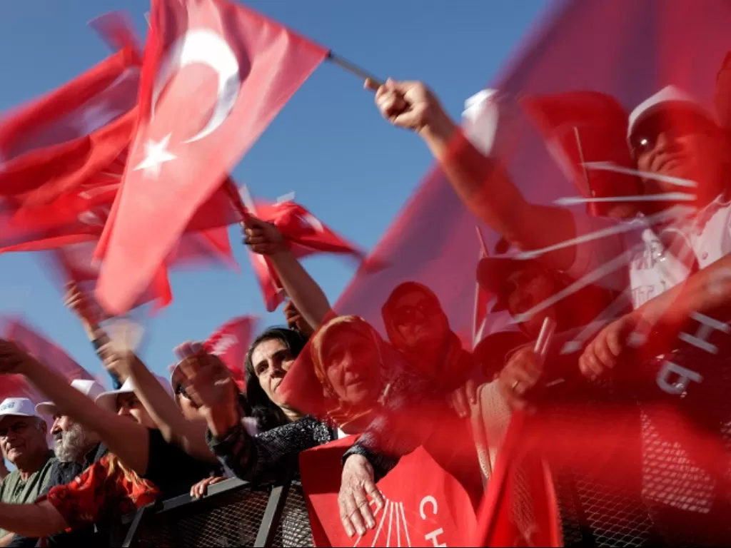 Warga Turki sedang mengibarkan bendera negara mereka. (REUTERS/Murad Sezer)