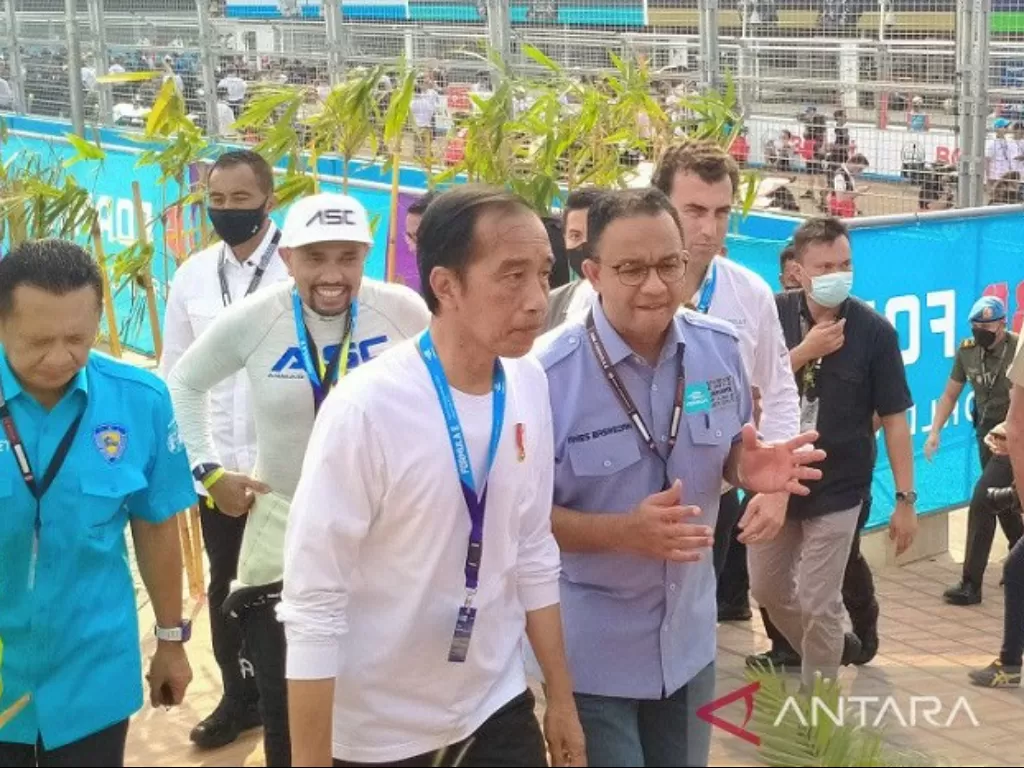 Presiden Joko Widodo tampak menerima penjelasan dari Gubernur DKI Jakarta Anies Baswedan seusai melakukan prosesi grid walk jelang dimulainya Jakarta E-Prix 2022. (ANTARA/Gilang Galiartha)