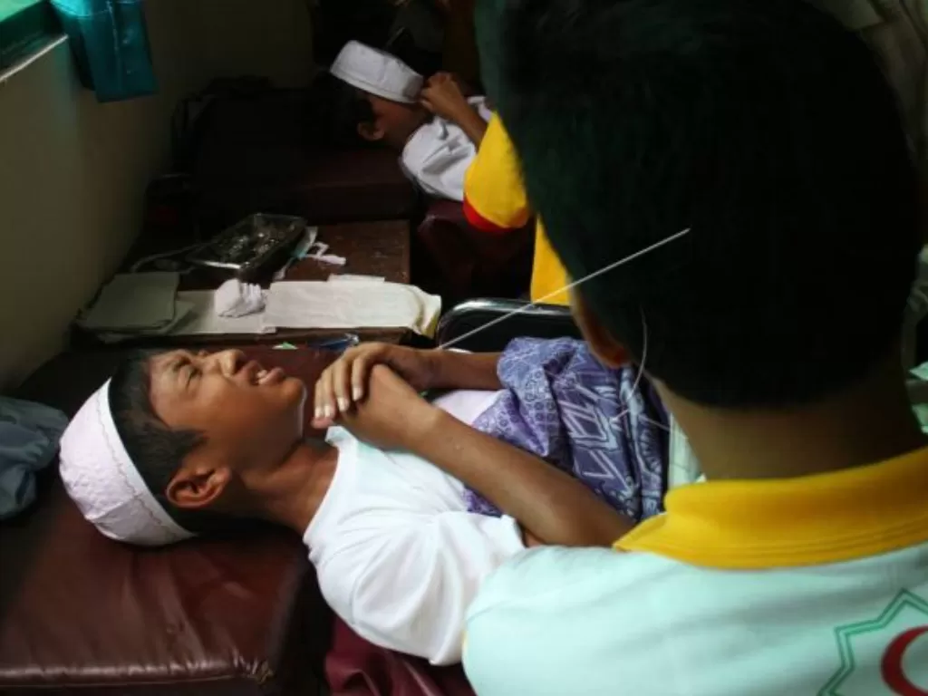 SUNAT MASSAL. Seorang anak meringgis saat disunat dalam sunatan massal di Mangkunegaran, Surakarta, Kamis (21/6). (FOTO ANTARA/Akbar Nugroho)