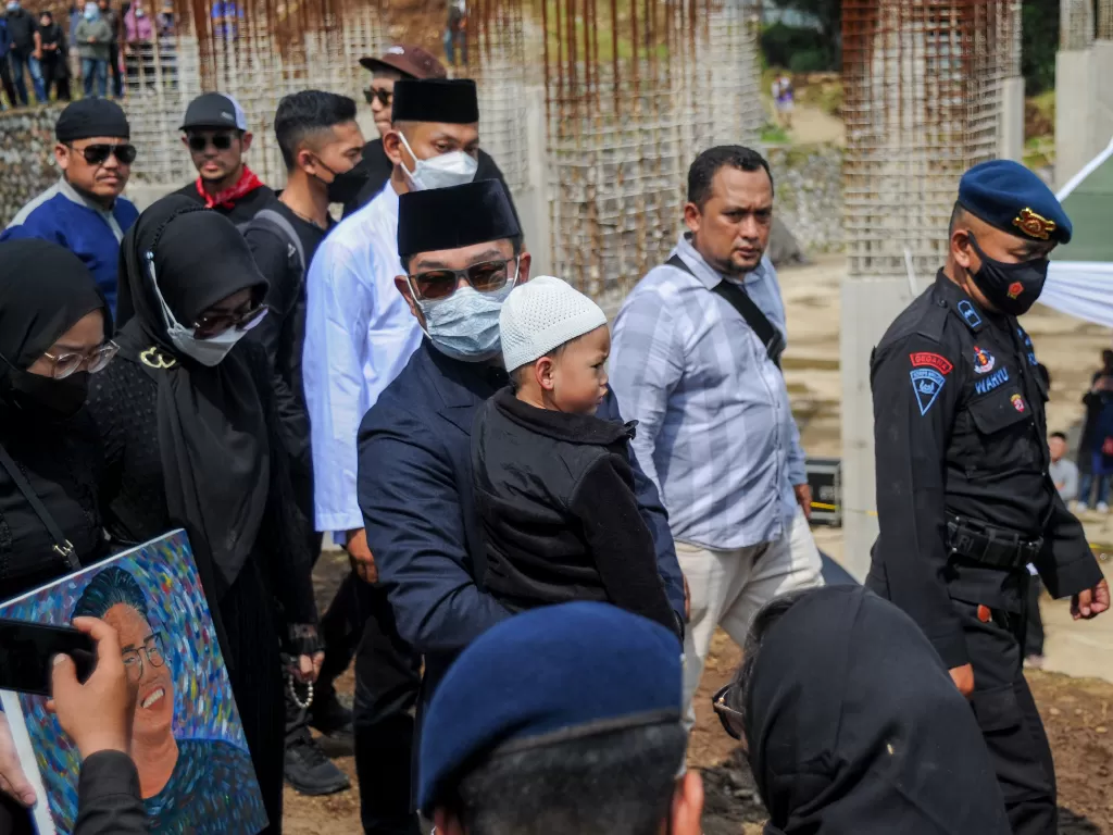 Gubernur Jawa Barat Ridwan Kamil (kedua kiri) mengikuti prosesi pemakaman putra sulungnya Emmeril Kahn Mumtadz di Cimaung, Banjaran, Kabupaten Bandung, Jawa Barat, Senin (13/6/2022). (ANTARA/Raisan Al Farisi)