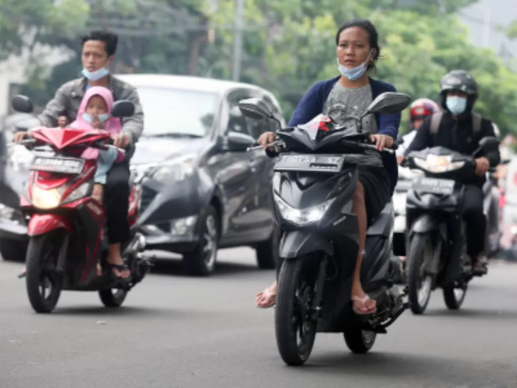 Sejumlah pengendara motor memakai sandal jepit melintas di Jalan Raya Ciledug, Kreo, Tangerang, Banten, Selasa (14/6/2022). (ANTARA FOTO/Muhammad Iqbal)