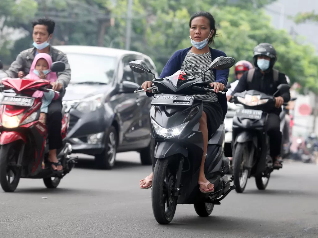 Sejumlah pengendara motor memakai sandal jepit melintas di Jalan Raya Ciledug, Kreo, Tangerang, Banten, Selasa (14/6/2022). (ANTARA/Muhammad Iqbal)
