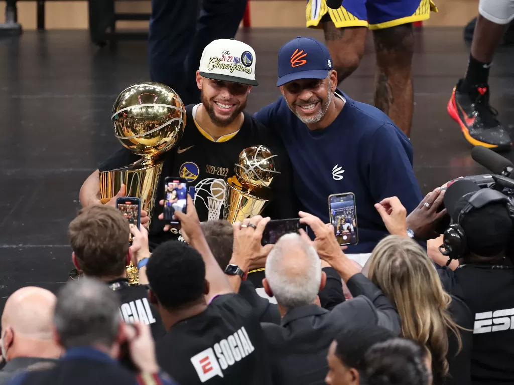 Guard Warriors, Stephen Curry (kanan) pegang trofi NBA 2022. (REUTERS/Paul Rutherford)