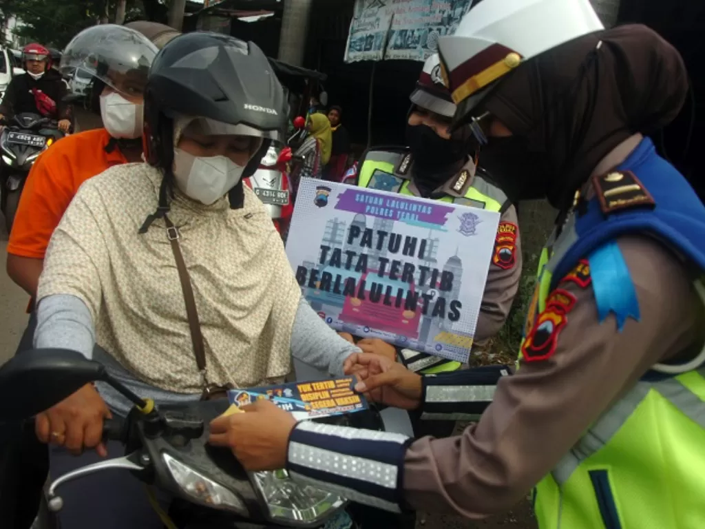 Polisi lalu lintas menilang pengendara sepeda motor saat Operasi Patuh. (ANTARA FOTO/Nyoman Hendra Wibowo)