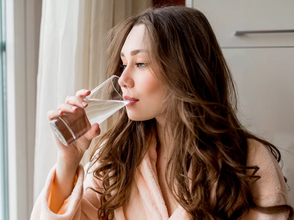 Ilustrasi wanita sedang meminum air (Freepik)