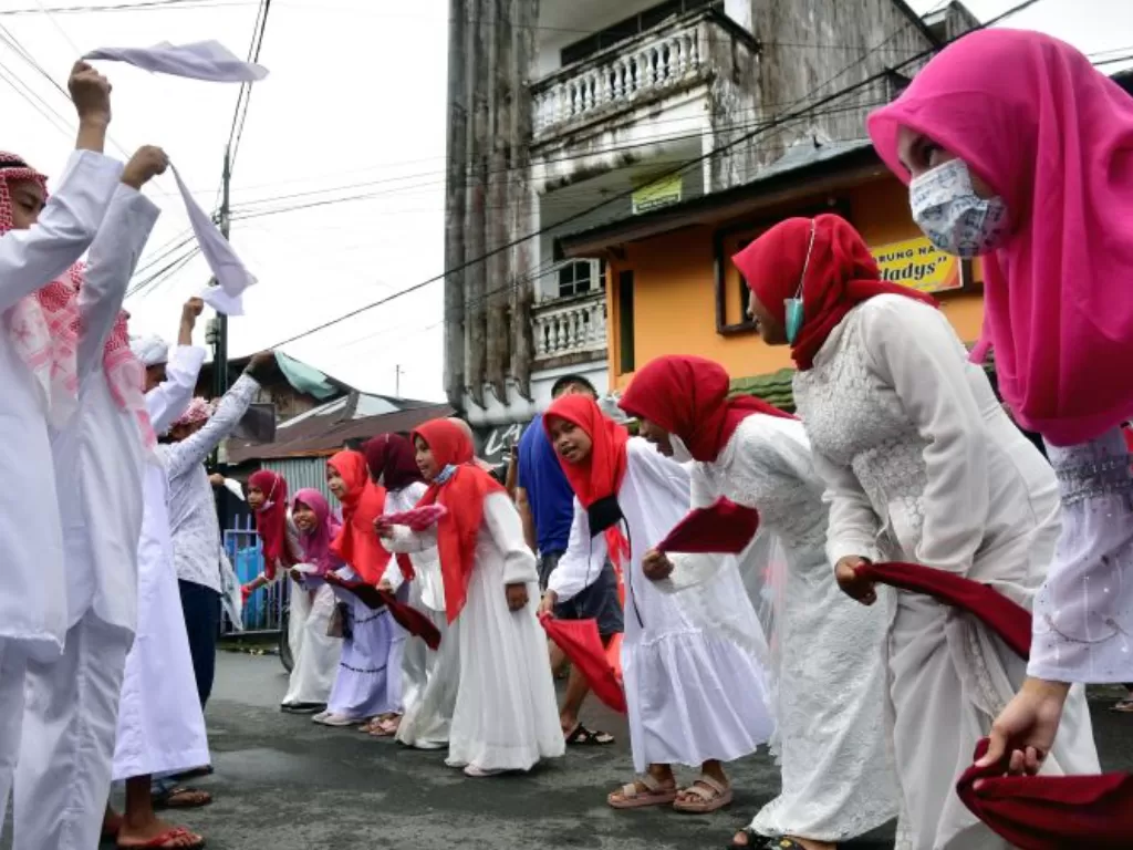  Sejumlah anak muda mengibaskan sapu tangan (Lenso) sambil bershalawat saat melakukan tradisi Hadrat pada Hari Raya Idul Adha 1442 Hijriyah di daerah Soa Bali Kota Ambon, Maluku, Selasa (20/7/2021). (ANTARA FOTO/FB Anggoro)
