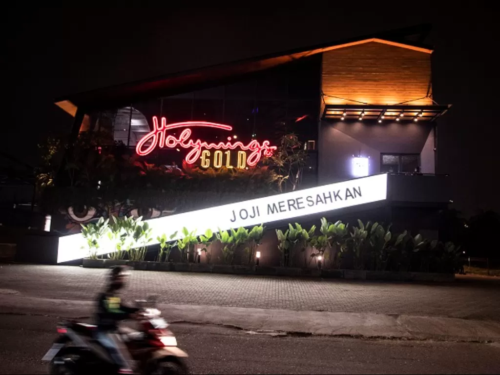 Pengendara sepeda motor melintas di depan outlet Holywing di Kelapa Gading, Jakarta. (ANTARA FOTO/Muhammad Adimaja)