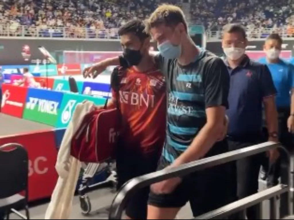 Vito memapah lawannya, Rasmus Gemke yang cedera hamstring di Malaysia Open 2022. (Screenshoot/Twitter/@INABadminton)