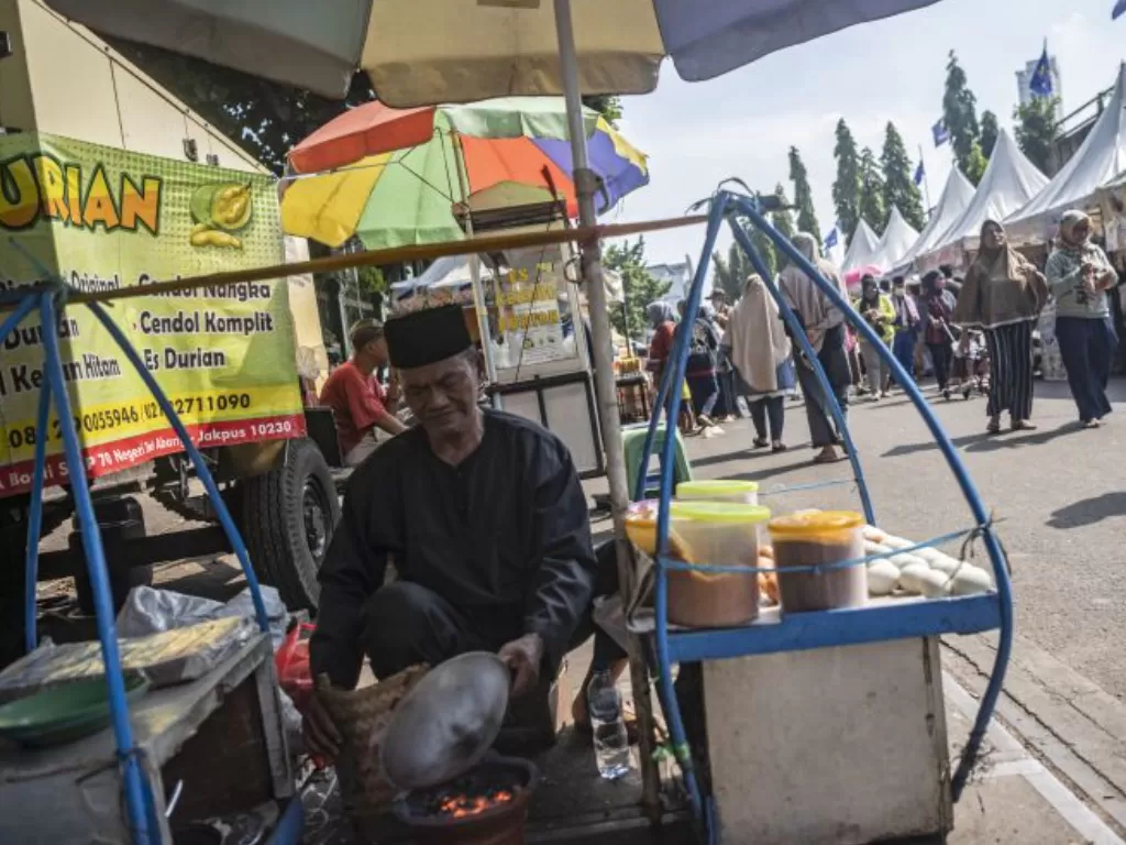 Pedagang kerak telor memasak untuk pembelinya dalam Lebaran Tenabang 2022 di depan Kantor Kecamatan Tanah Abang, Jakarta, Sabtu (4/6/2022). (ANTARA FOTO/Aprillio Akbar)