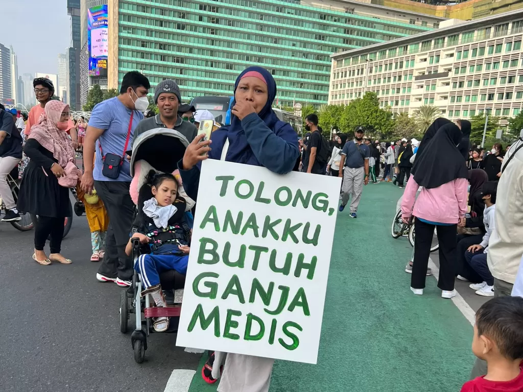 Ibu Santi Warastuti saat bentangkan poster 'Tolong anakku butuh ganja medis' di CPF di Bundaran HI, Jakarta Pusat. (Foto/Twitter @andienaisyah)