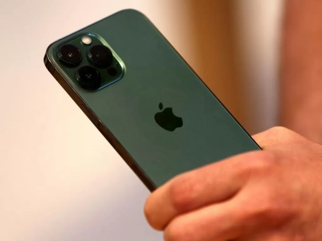 Seorang pelanggan memegang Apple iPhone 13 pro warna hijau baru tak lama setelah mulai dijual di dalam Apple Store di 5th Avenue di Manhattan di New York City, New York, AS, 18 Maret 2022. (REUTERS/Mike Segar)
