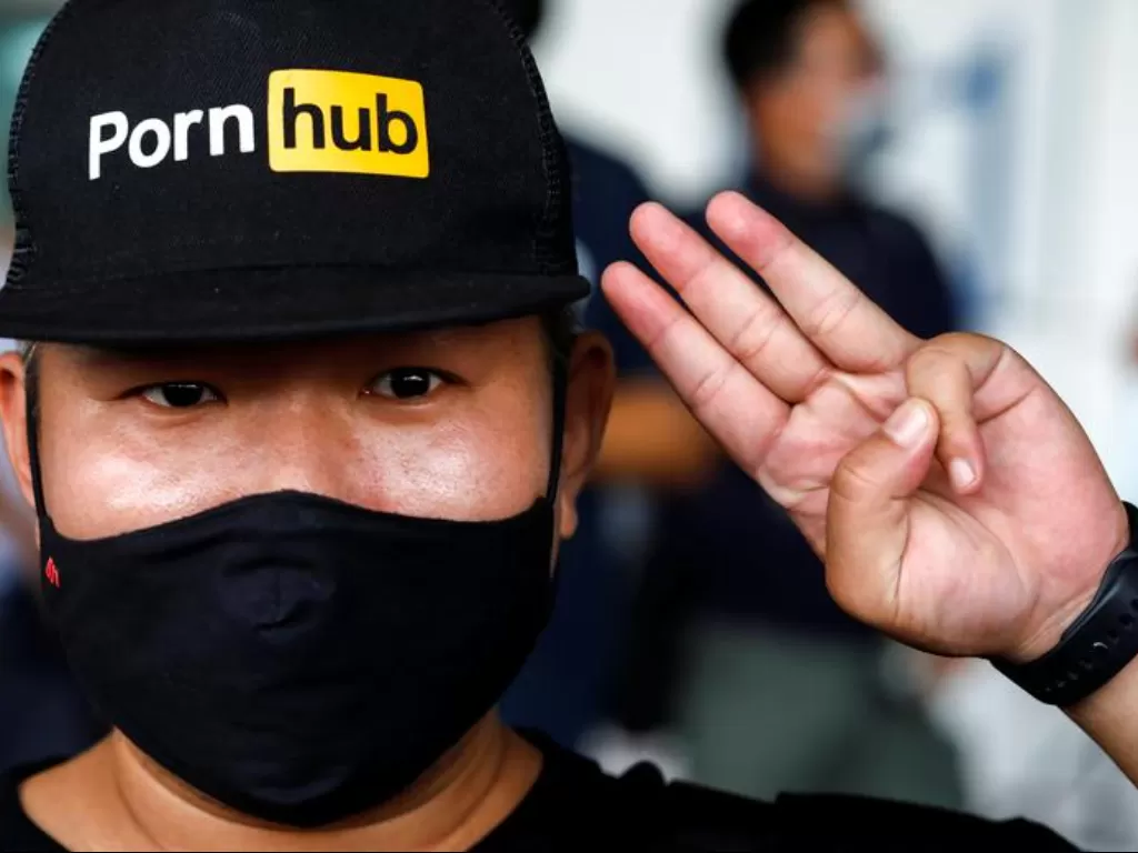 Seorang pengunjuk rasa mengenakan topi berlogo Pornhub saat aksi protes pemblokiran akses situs Pornhub oleh pemerintah Thailand. (REUTERS/Krit Phromsakla Na Sakolnakorn)