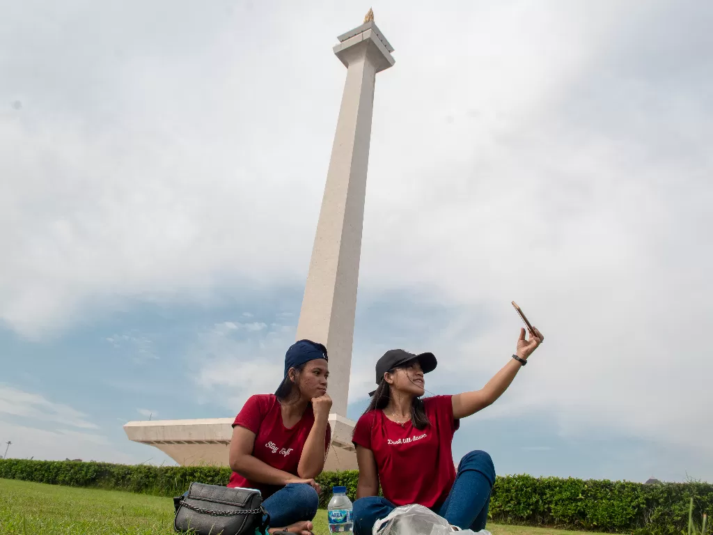Warga selfie di Monas saat PPKM lelev 1 di DKI Jakarta. (ANTARA FOTO/Muhammad Adimaja)