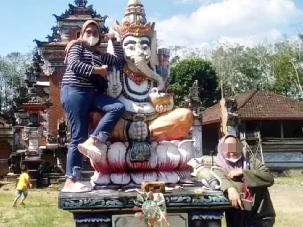 Wisatawan naiki patung Dewa Ganesha. (Instagram/@niluhdjelantik)