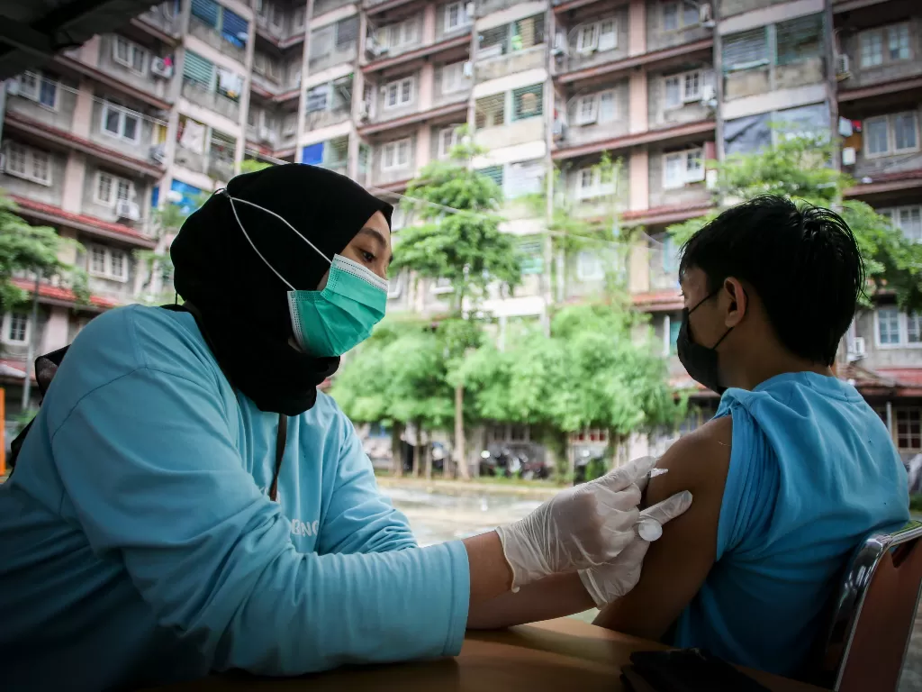Petugas menyuntikkan vaksin COVID-19 dosis ketiga kepada warga di RPTRA Rusun Benhil, Jakarta, Rabu (6/7/2022). (ANTARA FOTO/Rivan Awal Lingga)