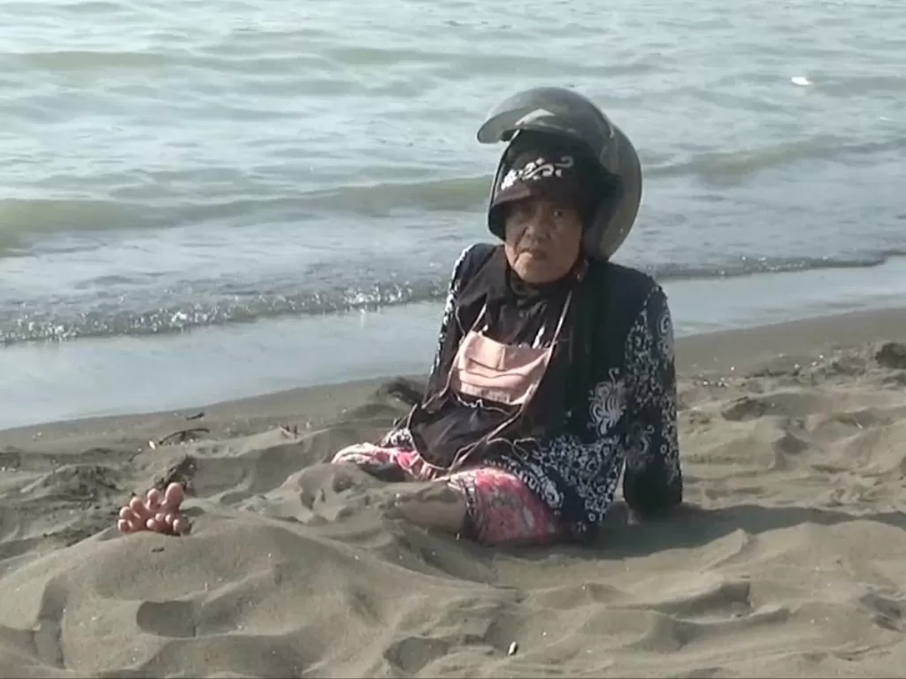Seorang ibu melakukan terapi pasir (Nurakhmawati/Z Creators)